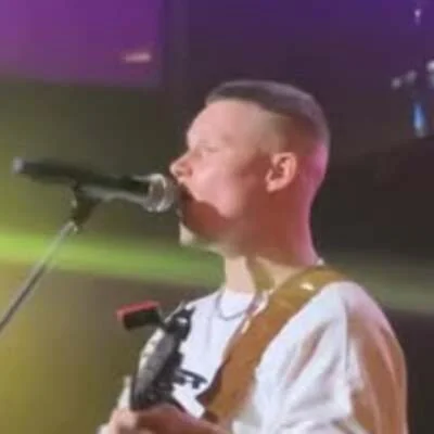 Андрей Заботин поёт у микрофона на сцене