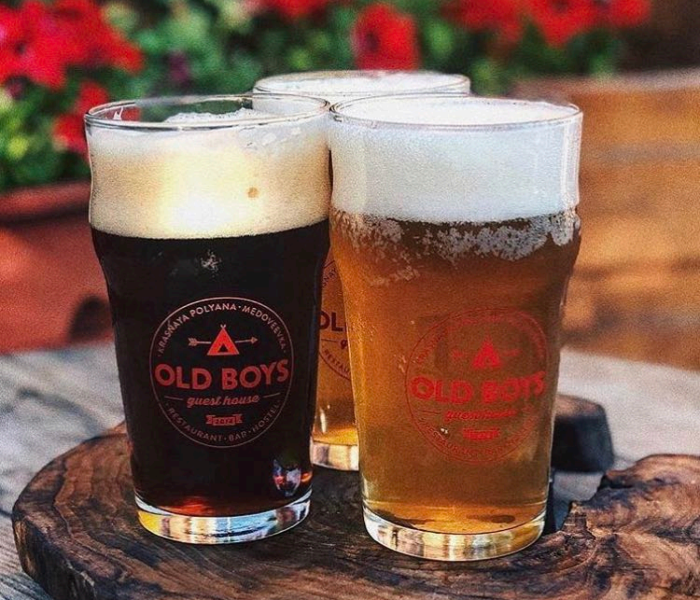 Бокалы тёмного и светлого пива с логотипом Old Boys на деревянном спиле